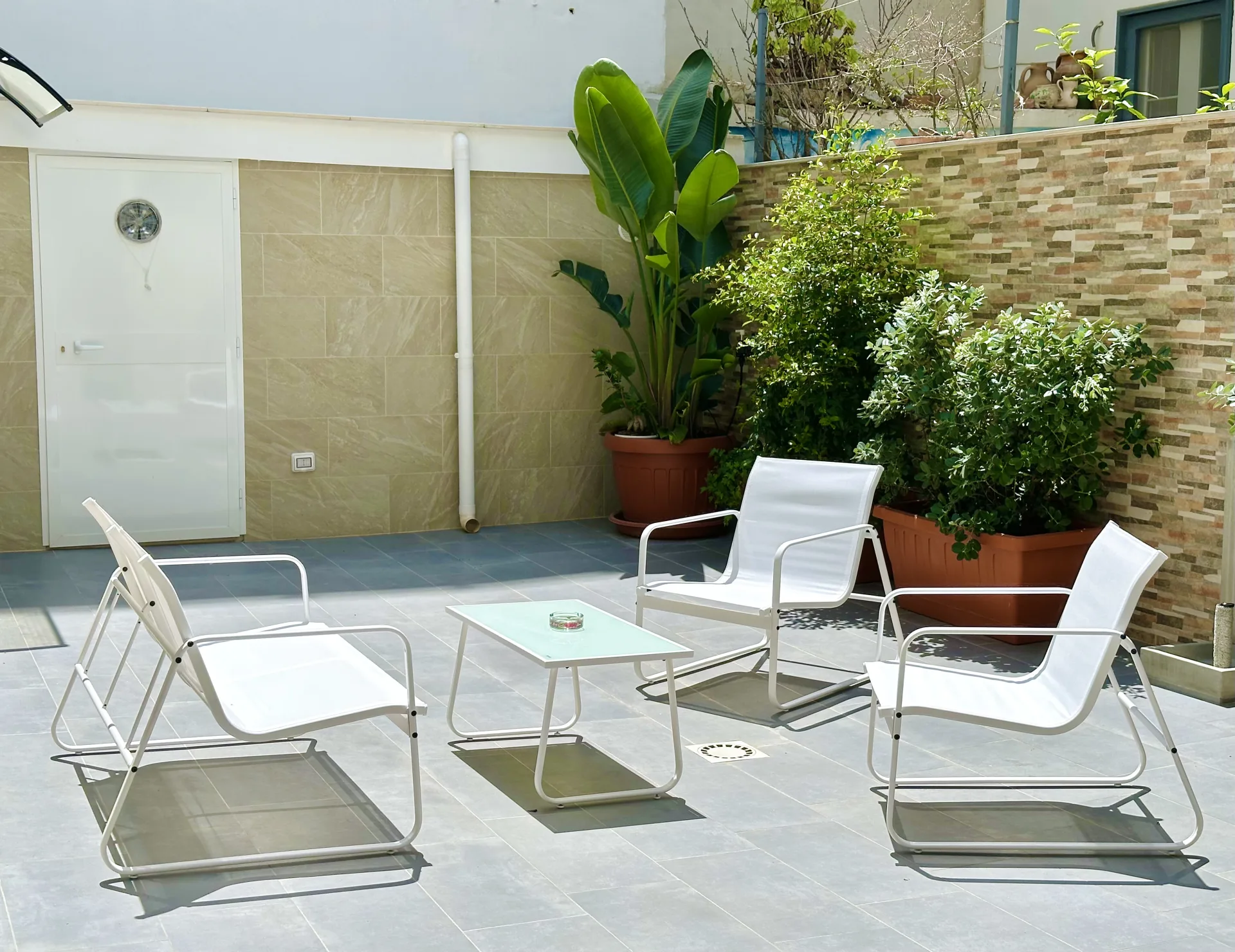 Il cortile comune di Casa Genzino con piante e arredi